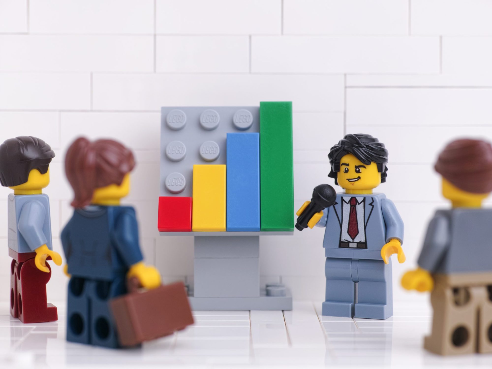 Tambov, Russian Federation - January 18, 2023 Lego businessperson minifigures having a meeting and discussing graphs that show the results of their successful teamwork.